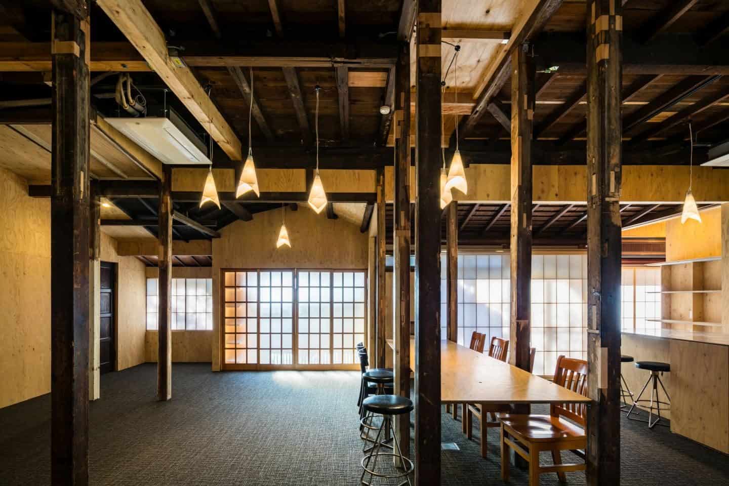 Japanese Style at Home Book Review - Exposed beams and columns add colour and texture to this large room, while low-hanging paper lanterns enhance the light from the large screened windows