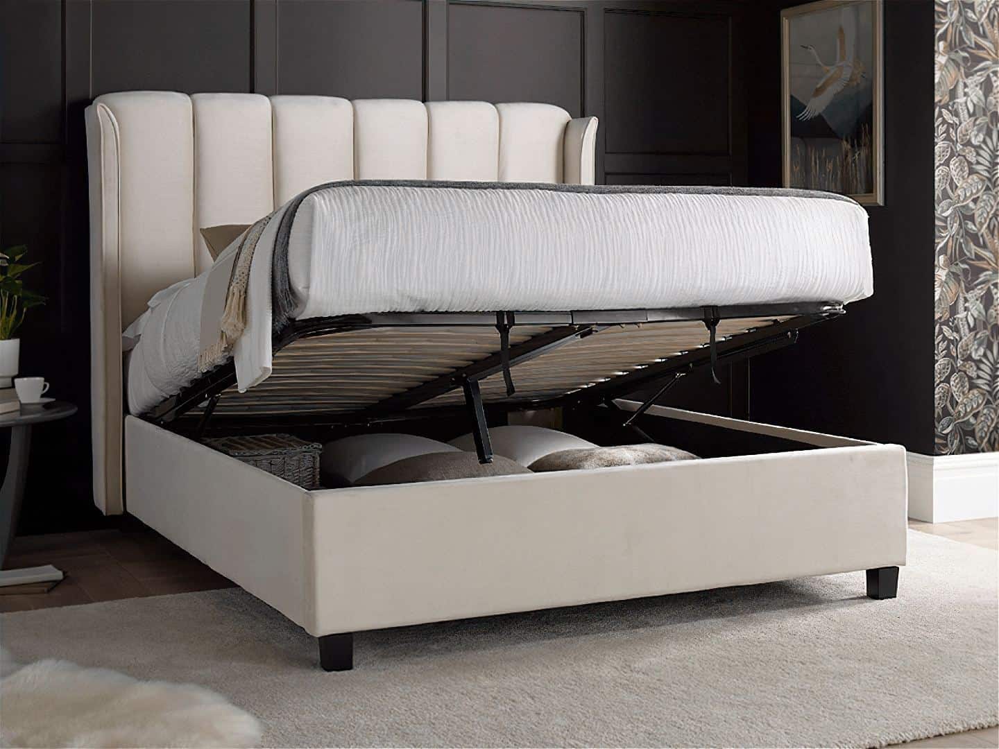 A bedroom featuring statement floral wallpaper and an ottoman bed with storage in stone