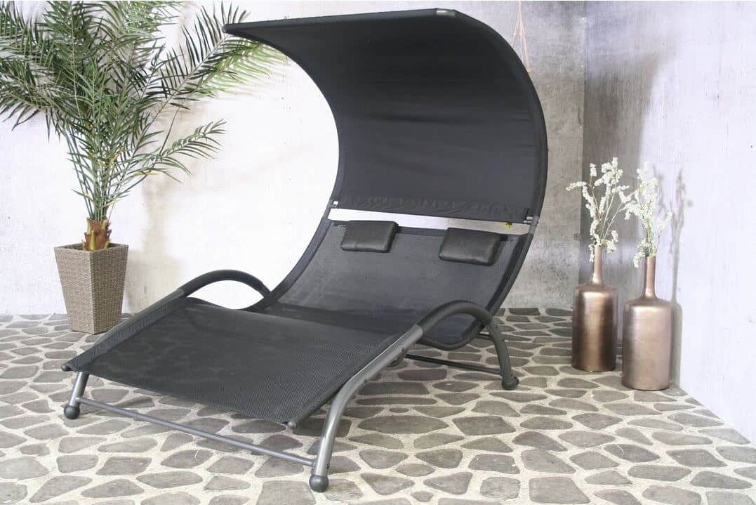 A double garden sun lounger in a cobbled courtyard