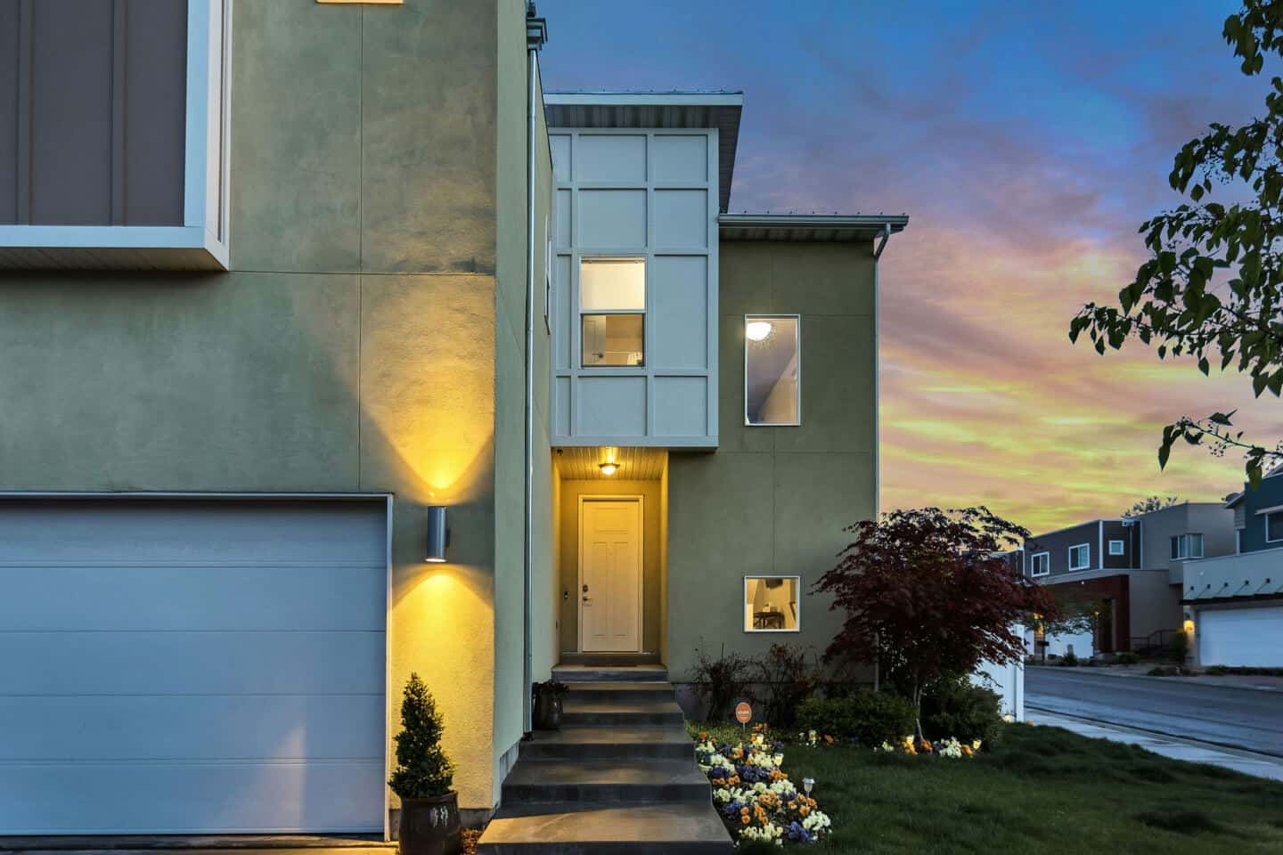 Exterior view of a modern home with outdoor lighting illuminating the front of the home