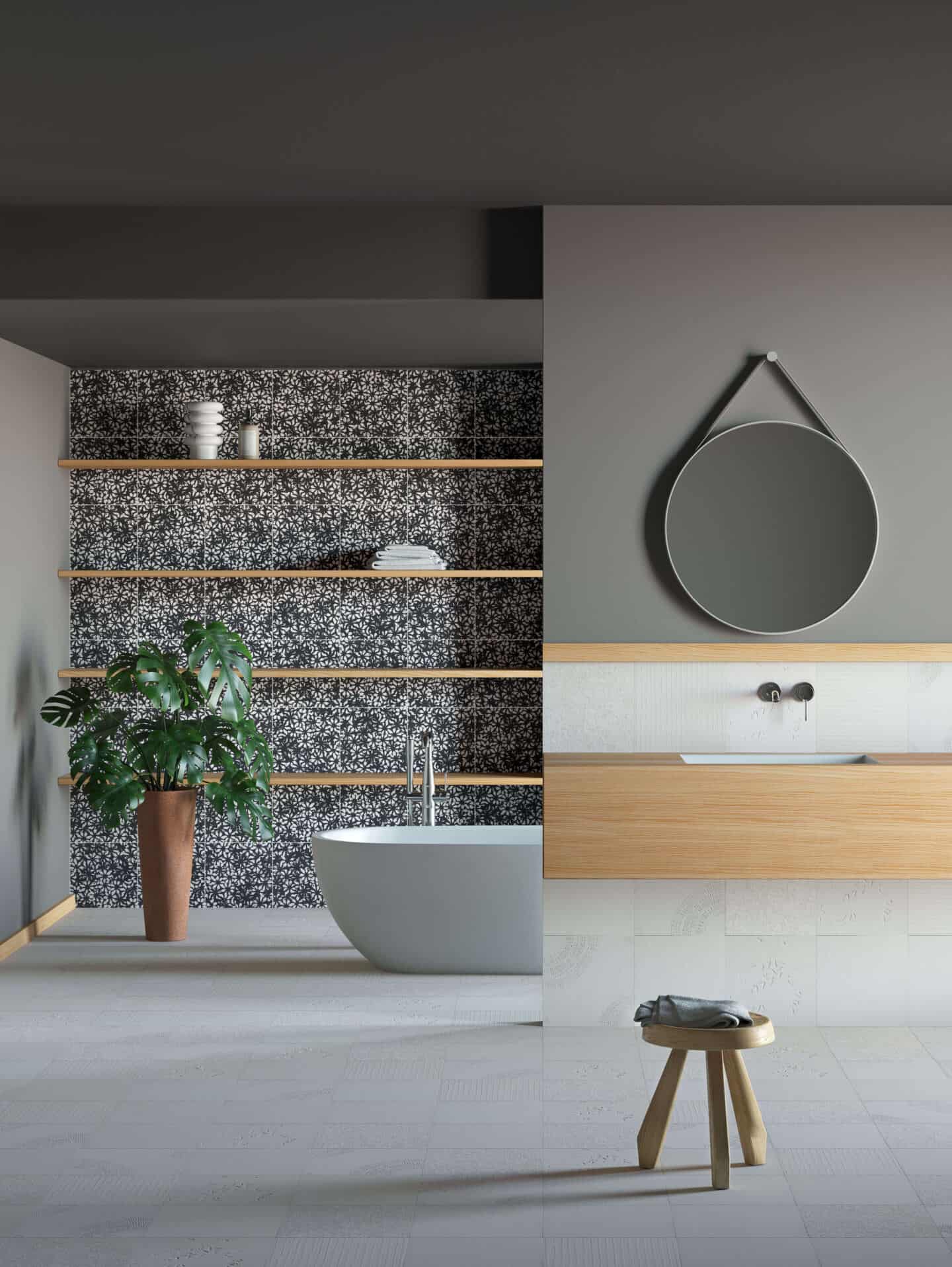 A large bright and airy bathroom with monochrome small flower print tiles on the wall, a freestanding white bathtub and a large Monstera plant in the corner.