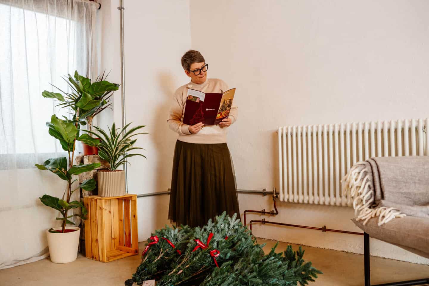 A woman in her forties reads the instructions for putting together a realistic Christmas tree from Balsam Hill