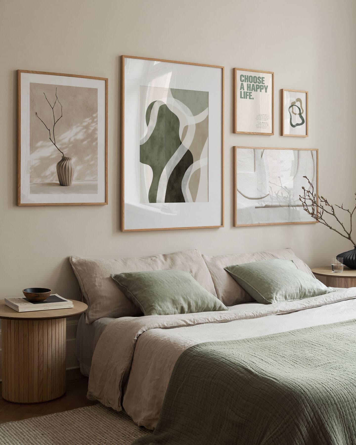 An elegant minimalist bedroom featuring beige and green linen bedding and a gallery wall of green and neutral Desenio artwork above the bed