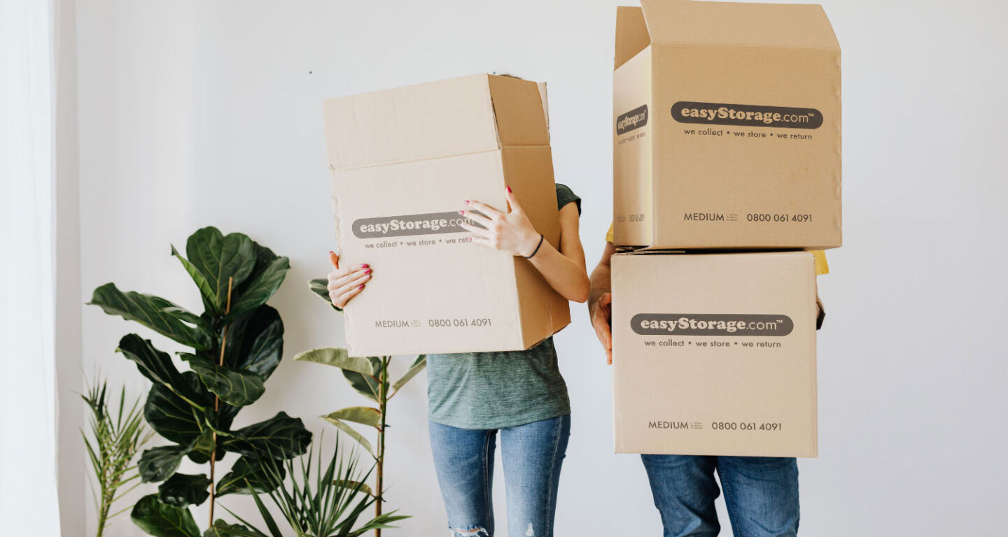 A man and a women carrying cardboard boxes