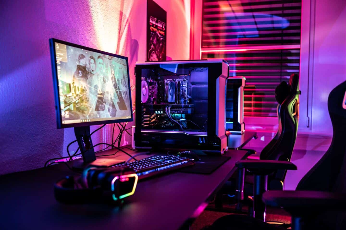 Home gaming set up. Two PC towers with transparent side panels on the casing, two gaming chairs and a screen