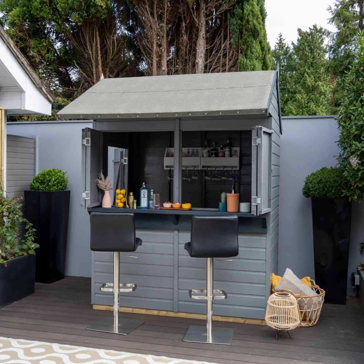 A garden shed painted grey and used as a bar