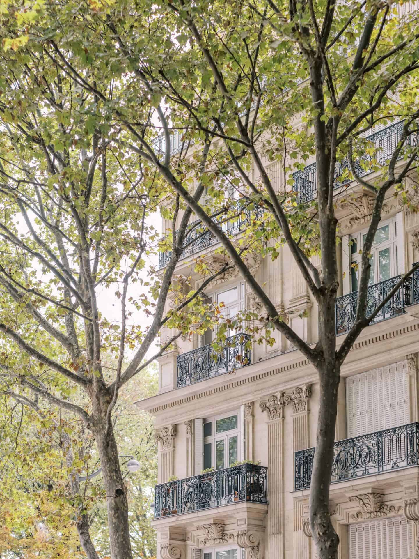 The exterior of a luxury home on a tree-lined street in Paris