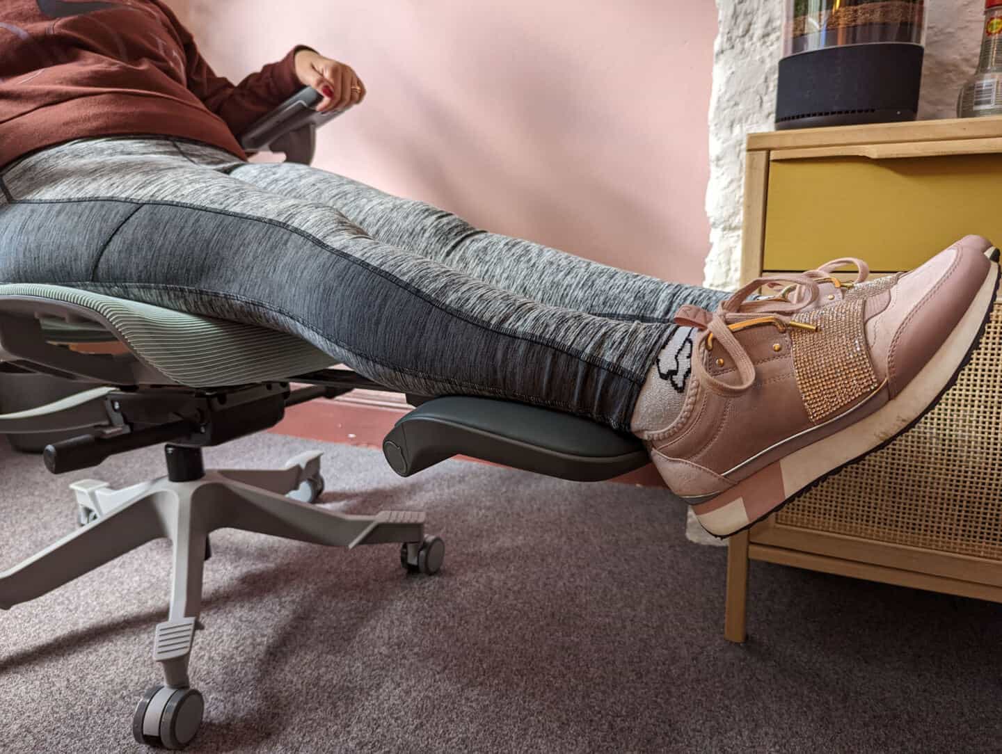 A closeup of the legs of a woman supported by the legrests of the Hinomi H1 Pro Ergonomic Office Chair