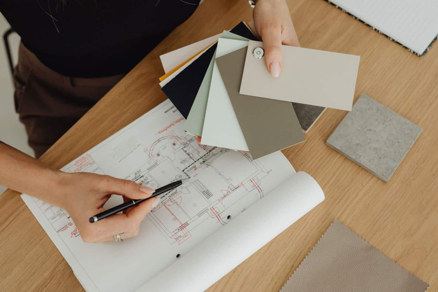 A female architect looks at floor plans and colour swatches