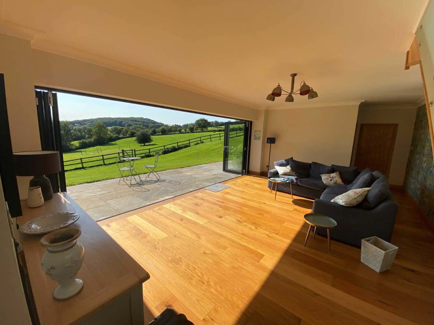 Aluminium bi-fold doors maximise the natural light and enable a seamless transition from inside this living room to the garden outside