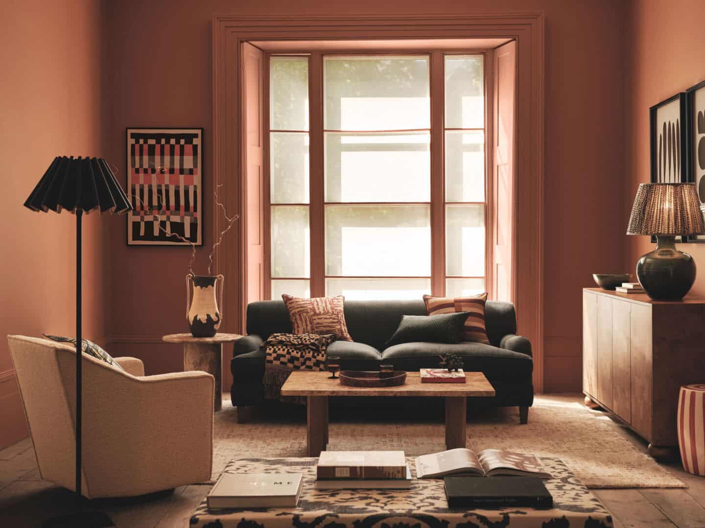 A living room in earthy colour palette with large windows to promote home health