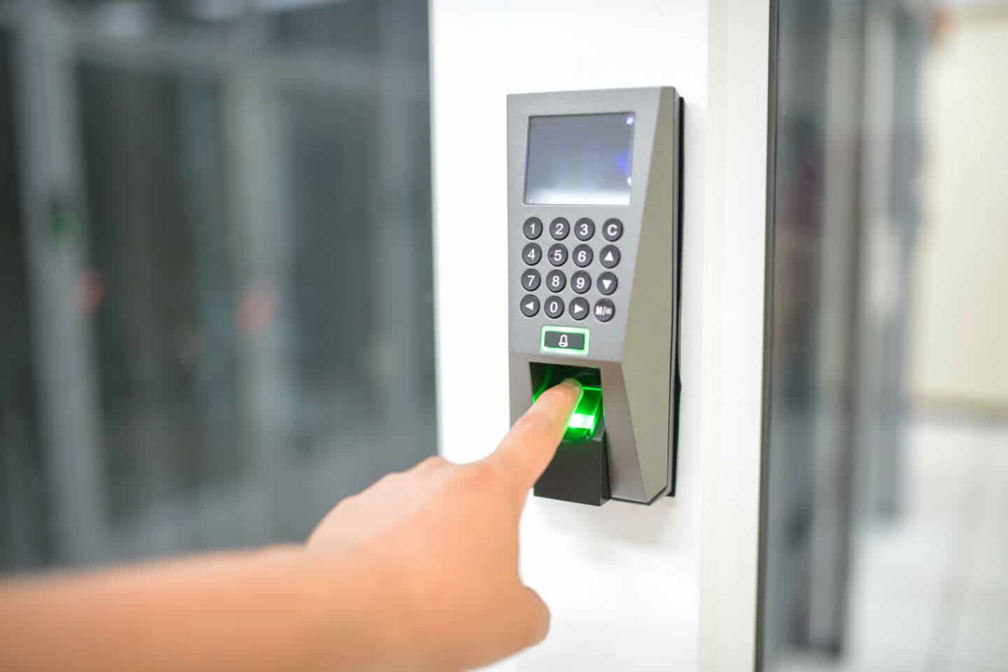 Someone putting a finger into a biometric home security device