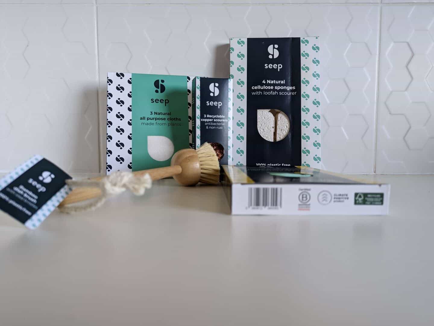 Eco-friendly, plastic-free cleaning products from Seep in packaging against a white tiled wall