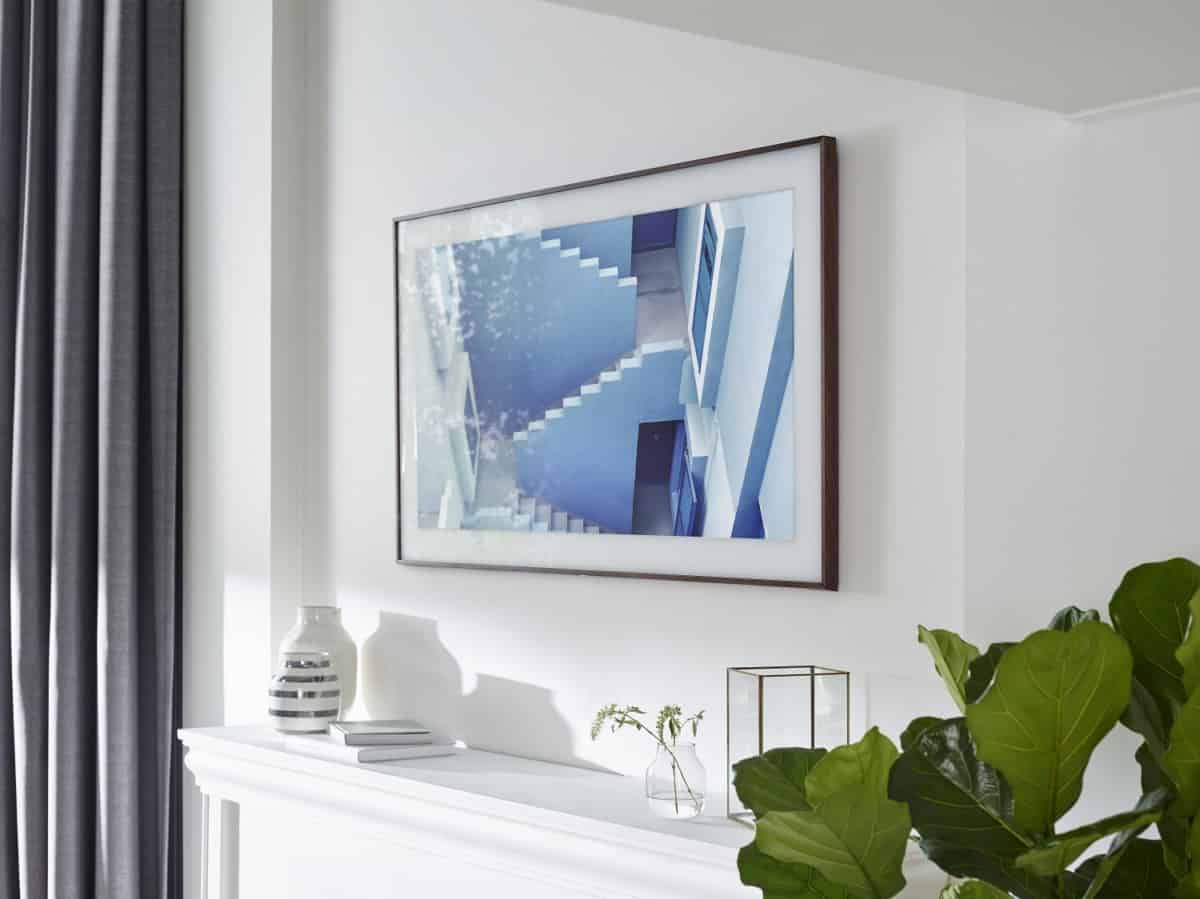 A Samsung Frame TV displaying artwork hung above a fireplace