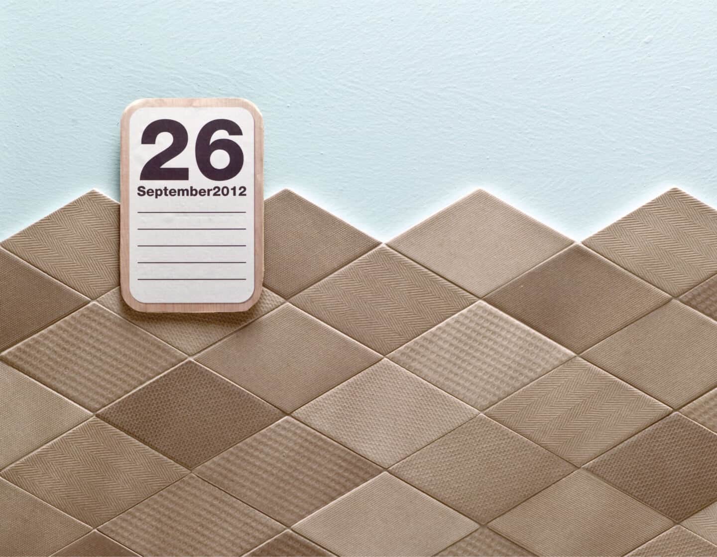 brown textured wall tiles. A calendar hangs on the wall.