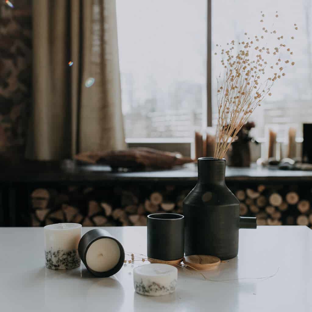 Textured Lives. Using texture in interiors to bring your home to life. Candles on a white surface next to a vase containing dried flowers