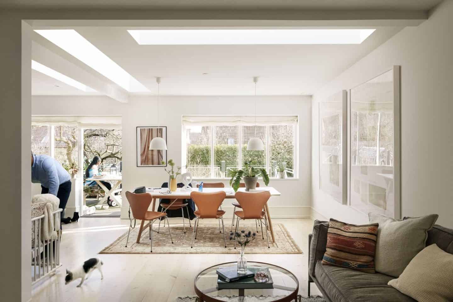 A dining room flooded with natural light pouring in from flat roof lights.