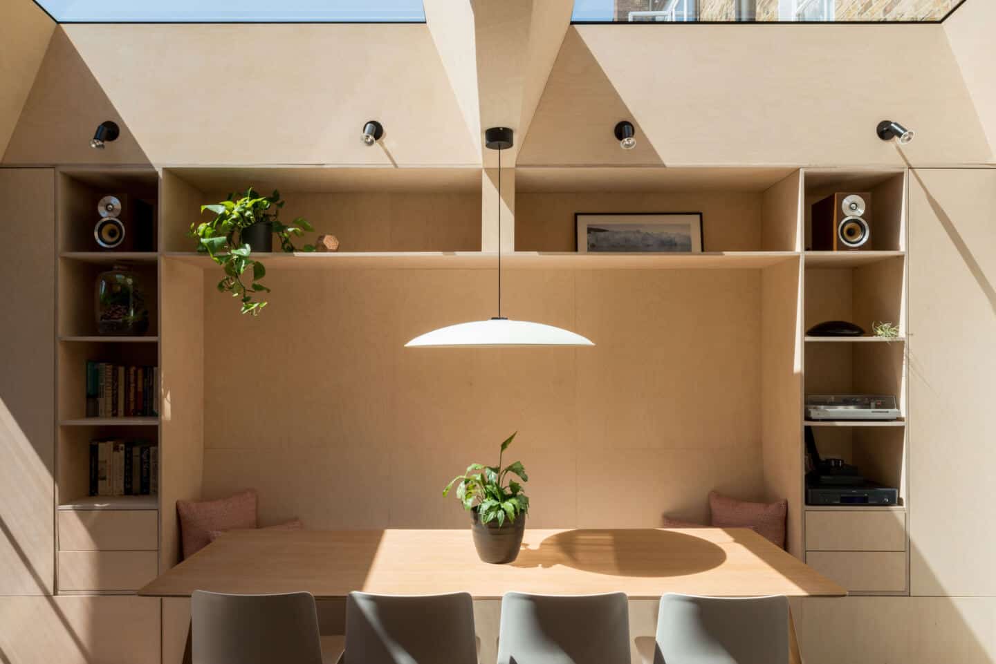 A dining nook flooded with natural light pouring in from flat roof lights.