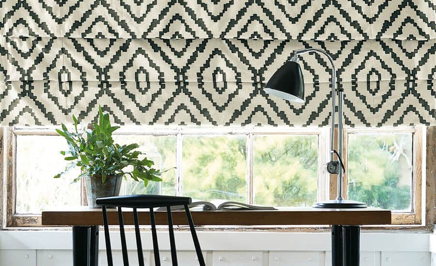 Made-to-measure blinds in Norrland fabric by Villa Nova. A desk sits in front of the window