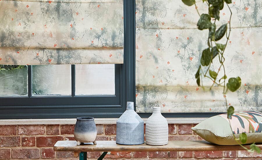 Made-to-Measure Blinds in Villa Nova fabric . Window in a raw brick wall with a bench in front.