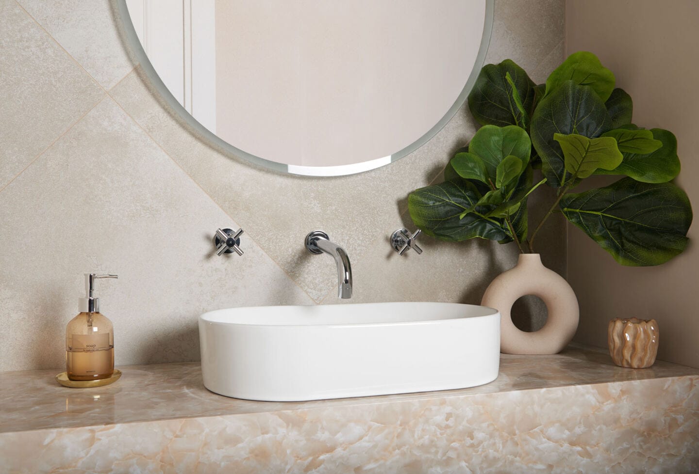 A bathroom sink with mirror above on a tiled wall and